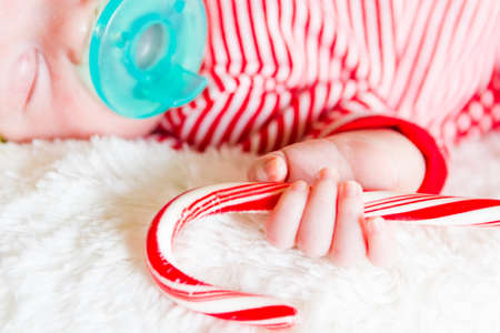 Newborn Christmas baby girl in elf hat on a white blanket.の写真素材