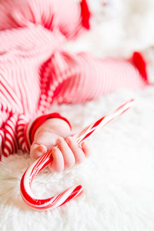 Newborn Christmas baby girl in elf hat on a white blanket.の写真素材
