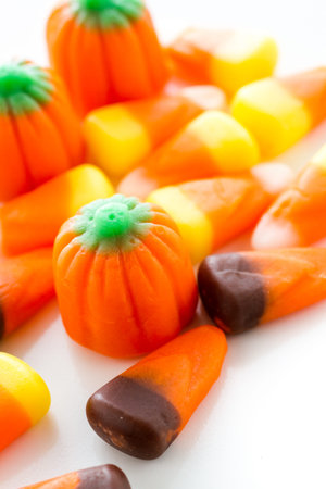 Halloween candy-corn and pumpkins in a pile.