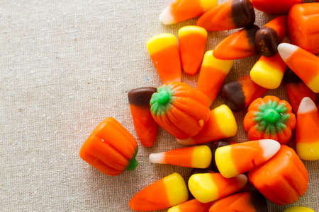 Halloween candy-corn and pumpkins in a pile.の写真素材