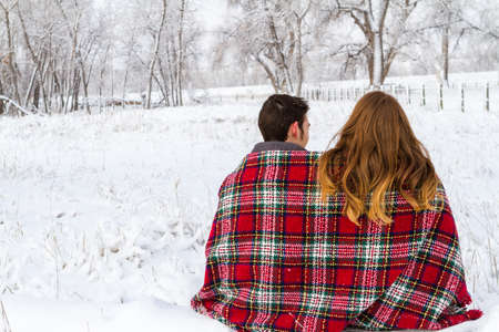 Young couple at the picnic on the Valentines Day in a snowy park.の写真素材