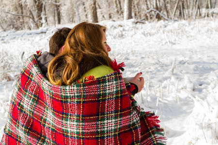 Young couple at the picnic on the Valentines Day in a snowy park.の写真素材