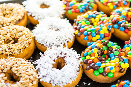 Fresh donuts with different toppings from the local bakery shop.のeditorial素材