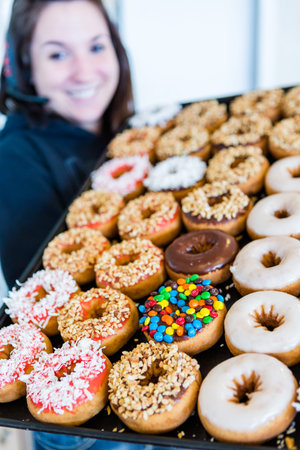 Variery of fresh donuts with different toppings from the local bakery shop.のeditorial素材