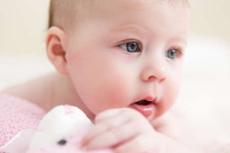 Infant baby girl playing on a pink blanket.の写真素材