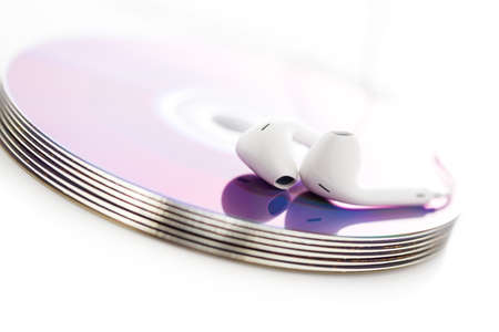 White headphones on top of CDs.の写真素材