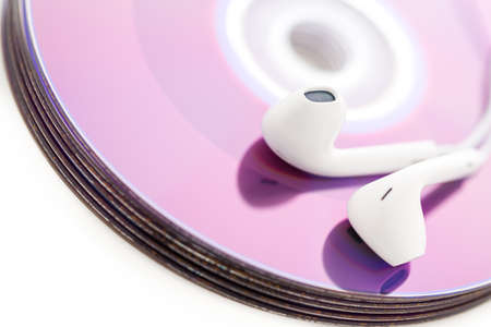 White headphones on top of CDs.の写真素材