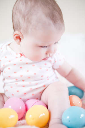 Little baby girl playing with Easter eggs.の写真素材