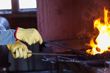 A blacksmith working at an old iron forge.の写真素材