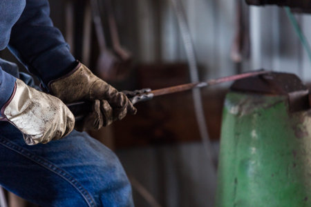 A blacksmith forging hot iron on the anvil.