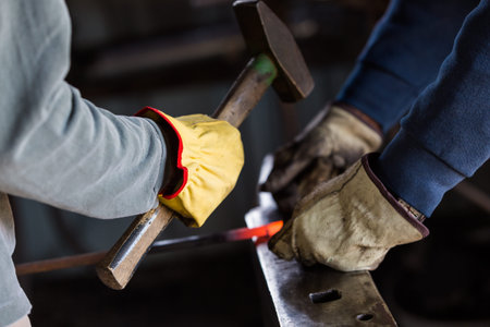A blacksmith forging hot iron on the anvil.