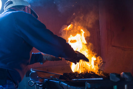 A blacksmith working at an old iron forge.