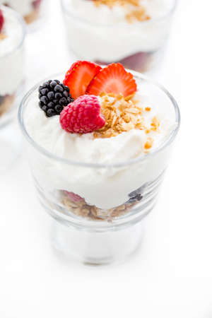 Breakfast parfait made from Greek yogurt and granola topped with fresh berries.の写真素材