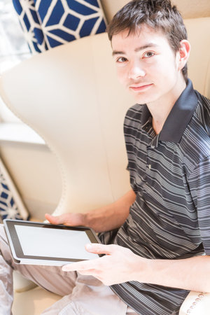 Teenage boy playing with his computer gadgets at leisure time.