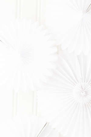 White paper fan in shape of pinwheel on a white background.の写真素材
