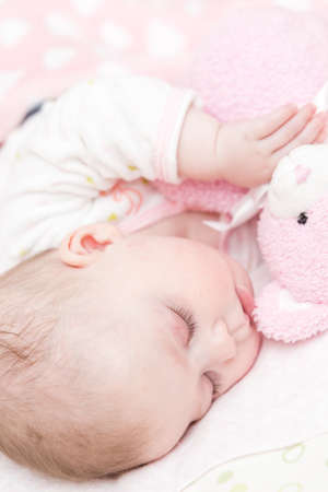 Cute baby girl sleeping in her crib.の写真素材