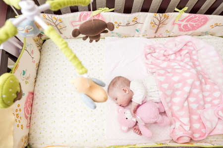 Cute baby girl sleeping in her crib.の写真素材
