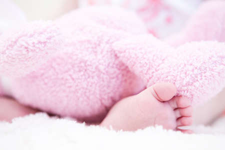 Baby girl playing with her toys on a white blanket.の写真素材