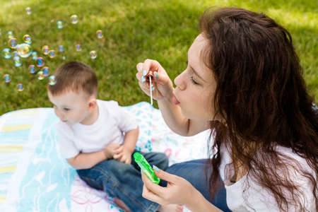 Young mother playing with her toddler son in the park.の写真素材