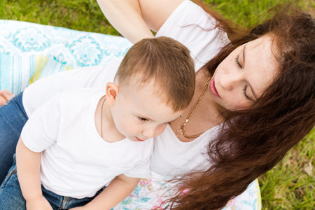 Young mother playing with her toddler son in the park.の写真素材