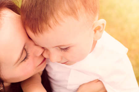 Young mother playing with her toddler son in the park.の写真素材