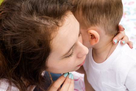 Young mother playing with her toddler son in the park.の写真素材