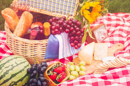 Summer picnic with a basket of food in the park.の写真素材