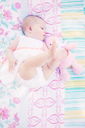 Cute baby girl playing on blanket in the park.の写真素材