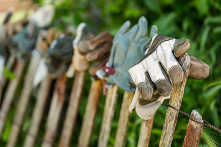 Fence decorated with old work gloves.の写真素材