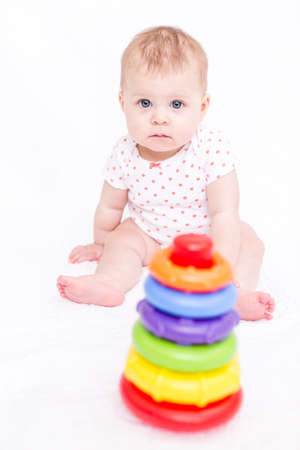 Cute baby girlplaying on a white blanket.の写真素材