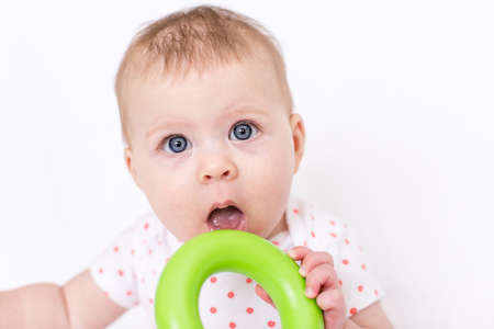 Cute baby girlplaying on a white blanket.の写真素材