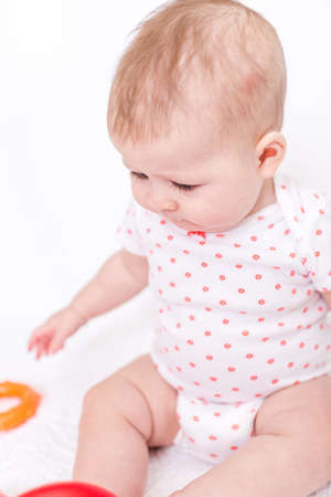 Cute baby girlplaying on a white blanket.の写真素材