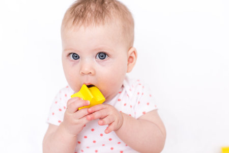 Cute baby girlplaying on a white blanket.