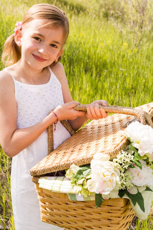 Cute girl with picnic basket in the countryside.の写真素材