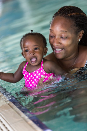 Infant swimming lessons in indoor pool.の写真素材