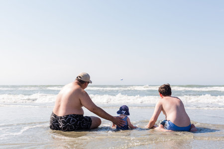 Family playing on the beach during their vacation.