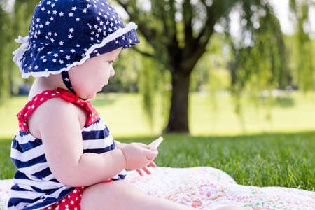 Cute baby girl celebrating 4th of July in the park.の写真素材