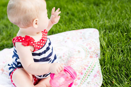 Cute baby girl celebrating 4th of July in the park.の写真素材