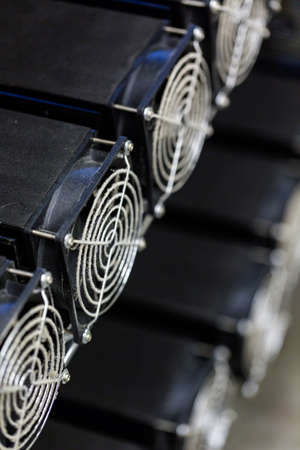 Row of litecoin miners set up on the wired shelfs.の写真素材