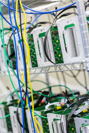 Denver, Colorado, USA-August 13, 2014. Row of bitcoin miners set up on the wired shelfs.のeditorial素材