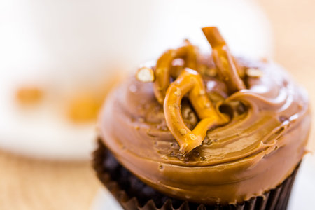Caramel crunch chocolate cupcake with caramel frosting topped with seasalt and pretzels.の写真素材
