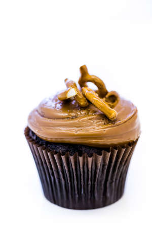 Caramel crunch chocolate cupcake with caramel frosting topped with seasalt and pretzels.の写真素材