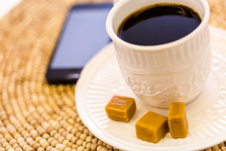 Hot coffee with caramel canies on the table.