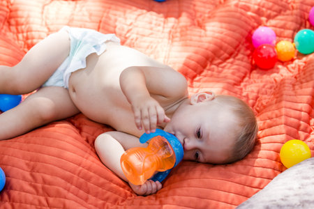 Cute babies playing on the blanket on backyard.