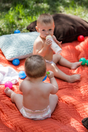 Cute babies playing on the blanket on backyard.の写真素材