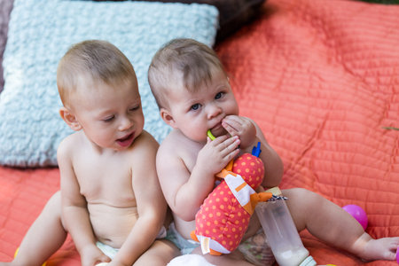 Cute babies playing on the blanket on backyard.の写真素材
