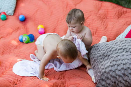 Cute babies playing on the blanket on backyard.の写真素材