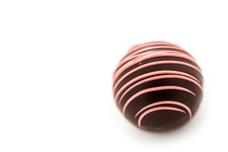 Gourmet strawberry chocolate truffle on a white background.