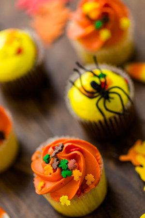 Assorted cupcakes with yellow and orange icing decorated for Autumn.の写真素材