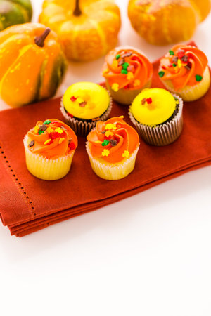 Assorted cupcakes with yellow and orange icing decorated for Autumn.の写真素材